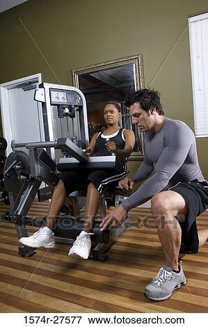 Trainer instructing a young woman with sports equipment in the gym View Large Photo Image Stock Photo - Trainer instructing a young woman with sports equipment in the gym. Fotosearch