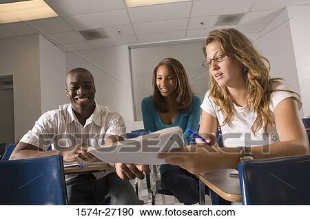 University students discussing with book in the classroom View Large Photo Image Stock Image - University students discussing with book in the classroom. Fotosearch
