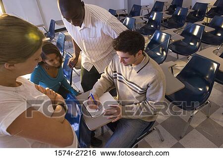 University students watching young man draw in a book in the classroom View Large Photo Image Stock Photograph - University students watching young man draw in a book in the classroom. Fotosearch
