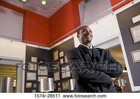 View of a well-dressed businessman smiling in an office View Large Photo Image Stock Image - View of a well-dressed businessman smiling in an office. Fotosearch