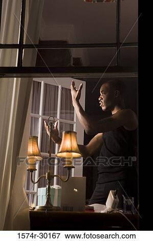 Stock Photo - View of a window with a man standing in the background. Fotosearch