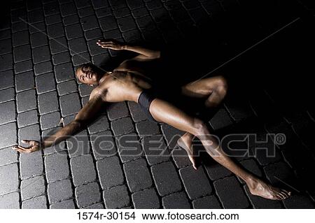 View of a young man lying on the tiled floor View Large Photo Image Picture - View of a young man lying on the tiled floor. Fotosearch