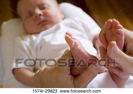 Woman holding her baby's legs View Large Photo Image Stock Image - Woman holding her baby's legs. Fotosearch
