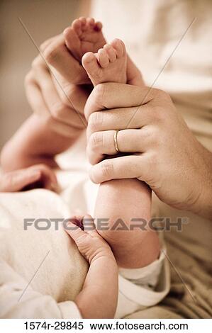 Woman holding her baby's legs View Large Photo Image Stock Photography - Woman holding her baby's legs. Fotosearch