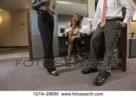 Young businesswoman looking at colleagues discussing View Large Photo Image Stock Photography - Young businesswoman looking at colleagues discussing. Fotosearch