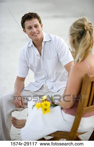 Young couple conversing at the beach View Large Photo Image Stock Photo - Young couple conversing at the beach. Fotosearch