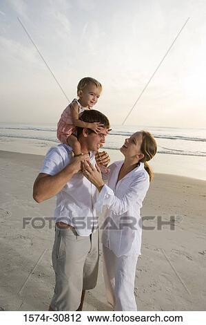 Young couple playing with daughter on the beach View Large Photo Image Stock Image - Young couple playing with daughter on the beach. Fotosearch