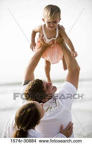 Young couple playing with their daughter on the beach View Large Photo Image Picture - Young couple playing with their daughter on the beach. Fotosearch