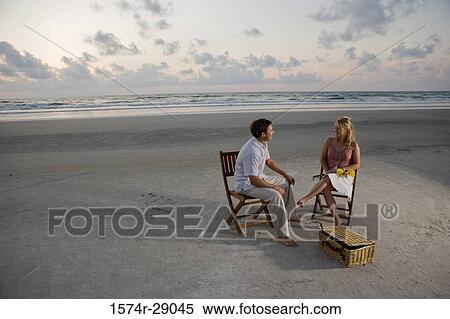 Young couple relaxing on chairs at the beach View Large Photo Image Stock Photography - Young couple relaxing on chairs at the beach. Fotosearch
