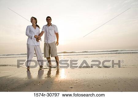 Young couple relaxing on the beach View Large Photo Image Stock Photo - Young couple relaxing on the beach. Fotosearch