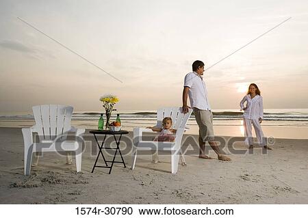 Young couple relaxing on the beach with daughter View Large Photo Image Stock Image - Young couple relaxing on the beach with daughter. Fotosearch