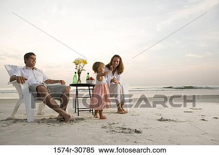 Stock Photography - Young couple with daughter relaxing on the beach. Fotosearch