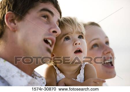 Young couple with their daughter looking up View Large Photo Image Stock Image - Young couple with their daughter looking up. Fotosearch