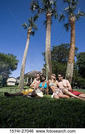 Young man and woman relaxing on lawn View Large Photo Image Stock Photograph - Young man and woman relaxing on lawn. Fotosearch