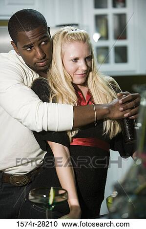 Young man embracing mid adult woman View Large Photo Image Stock Image - Young man embracing mid adult woman. Fotosearch