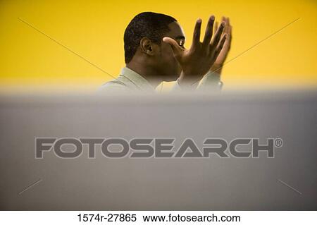 Stock Photography - Young man gesturing in an office. Fotosearch