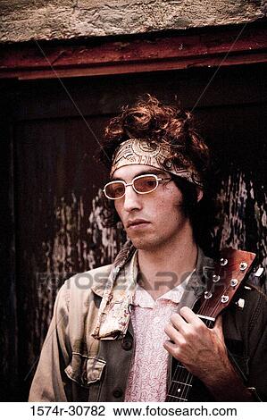 Stock Image - Young man holding a guitar. Fotosearch