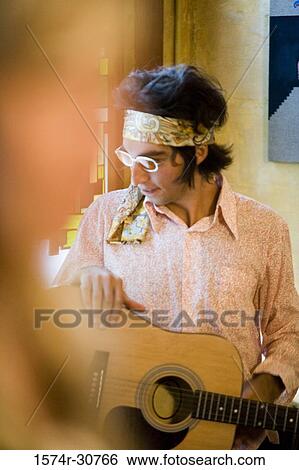 Stock Photograph - Young man holding a guitar. Fotosearch
