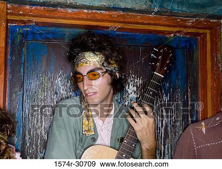 Young man holding guitar with sister beside View Large Photo Image Stock Photo - Young man holding guitar with sister beside. Fotosearch