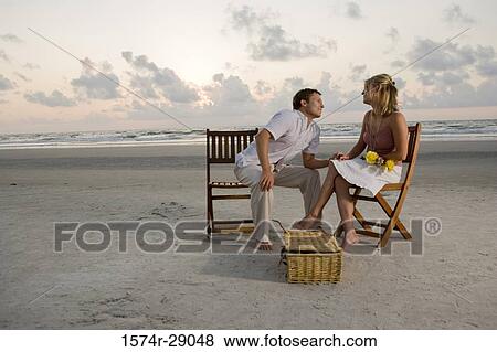 Young man holding hand of a young woman at the beach View Large Photo Image Stock Photo - Young man holding hand of a young woman at the beach. Fotosearch