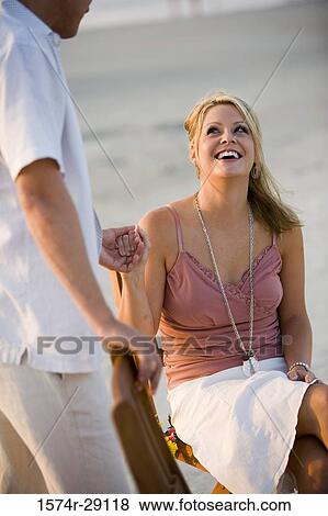 Young man holding hand of a young woman at the beach View Large Photo Image Stock Photo - Young man holding hand of a young woman at the beach. Fotosearch