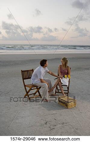 Young man holding hand of a young woman at the beach View Large Photo Image Stock Photograph - Young man holding hand of a young woman at the beach. Fotosearch