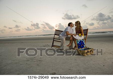 Young man kissing a young woman at the beach View Large Photo Image Stock Photo - Young man kissing a young woman at the beach. Fotosearch