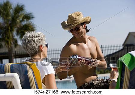 Young man pouring drink into senior women's glass View Large Photo Image Stock Photo - Young man pouring drink into senior women's glass. Fotosearch