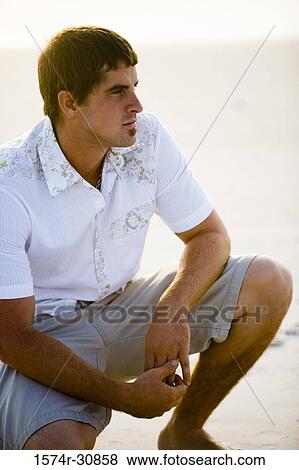 Stock Photo - Young man relaxing on the beach. Fotosearch