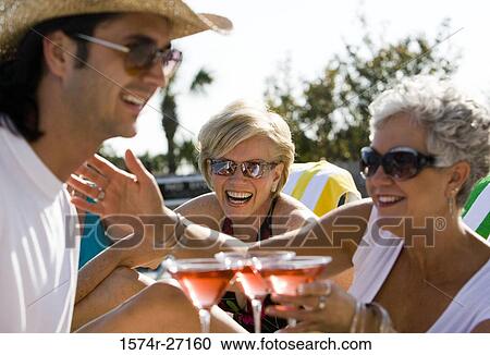 Young man serving drinks to senior women View Large Photo Image Stock Image - Young man serving drinks to senior women. Fotosearch