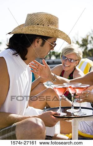 Young man serving drinks to senior women View Large Photo Image Stock Image - Young man serving drinks to senior women. Fotosearch