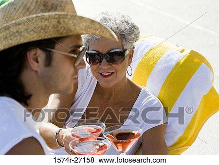 Young man serving drinks to senior women View Large Photo Image Stock Photo - Young man serving drinks to senior women. Fotosearch