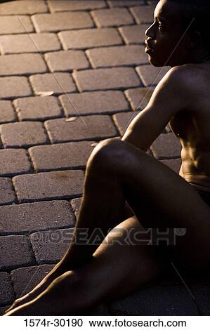 Young man sitting on the tiled floor View Large Photo Image Stock Image - Young man sitting on the tiled floor. Fotosearch