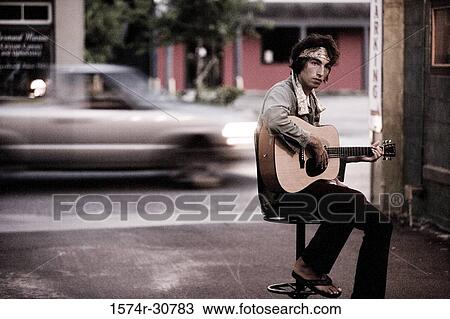 Young man sitting with guitar View Large Photo Image Stock Image - Young man sitting with guitar. Fotosearch