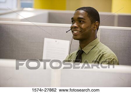 Young man using headset in an office View Large Photo Image Stock Image - Young man using headset in an office. Fotosearch