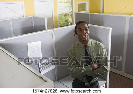 Young man using headset in an office View Large Photo Image Stock Photograph - Young man using headset in an office. Fotosearch