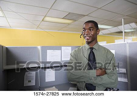 Young man using headset in an office View Large Photo Image Stock Photography - Young man using headset in an office. Fotosearch