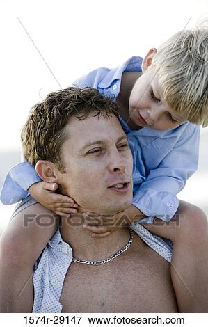 Young man with son on shoulders at the beach View Large Photo Image Stock Photo - Young man with son on shoulders at the beach. Fotosearch