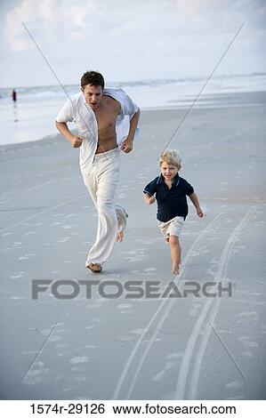 Young man with son running at the beach View Large Photo Image Stock Photograph - Young man with son running at the beach. Fotosearch
