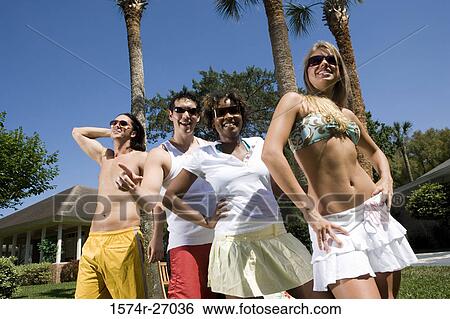 Stock Photograph - Young men and young women standing on lawn. Fotosearch