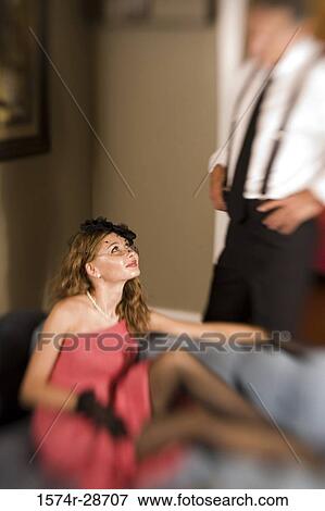 Young prostitute in a red dress sitting on sofa and looking at a mid adult man View Large Photo Image Stock Photo - Young prostitute in a red dress sitting on sofa and looking at a mid adult man. Fotosearch