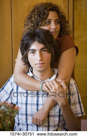 Stock Image - Young woman embracing her brother. Fotosearch