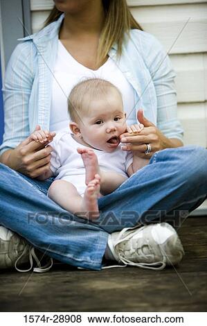 Young woman holding her baby on lap View Large Photo Image Stock Photo - Young woman holding her baby on lap. Fotosearch