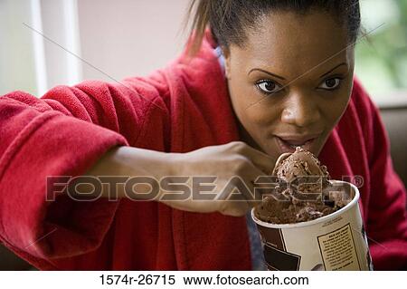 Young woman in gown eating an ice cream View Large Photo Image Stock Photography - Young woman in gown eating an ice cream. Fotosearch