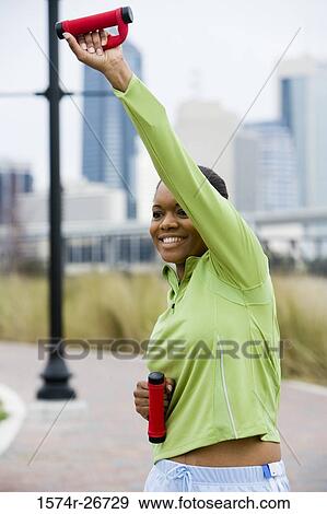 Stock Photo - Young woman in sports clothing jogging on walkway. Fotosearch