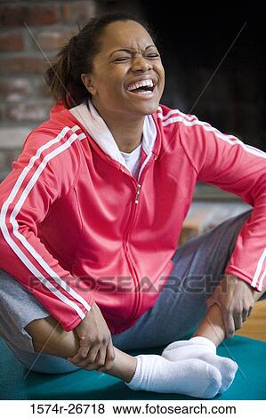 Young woman in sports clothing exercising on mat by fire place View Large Photo Image Stock Photo - Young woman in sports clothing exercising on mat by fire place. Fotosearch