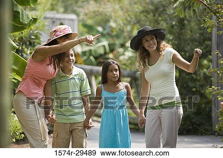 Stock Photo - Young woman pointing while other looking up. Fotosearch