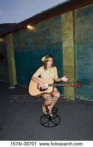 Young woman sitting with a guitar View Large Photo Image Stock Image - Young woman sitting with a guitar. Fotosearch