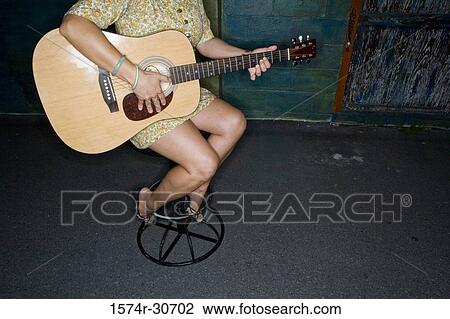 Young woman sitting with a guitar View Large Photo Image Stock Image - Young woman sitting with a guitar. Fotosearch