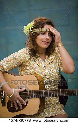 Young woman sitting with a guitar View Large Photo Image Stock Photo - Young woman sitting with a guitar. Fotosearch
